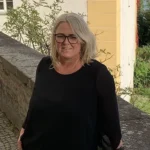 Frau mit schwarzem Pulli. lange blonde Haare, Brille